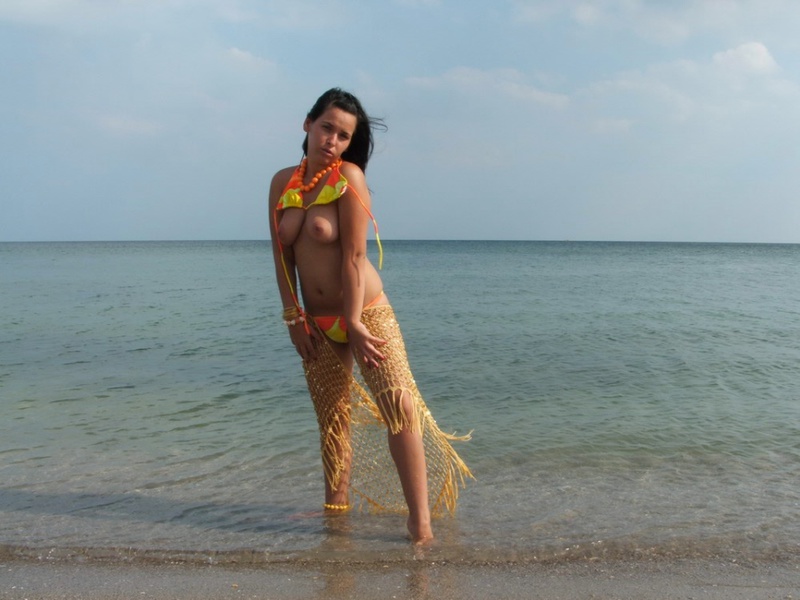 Грудастая модель позирует голой на берегу моря - секс порно фото