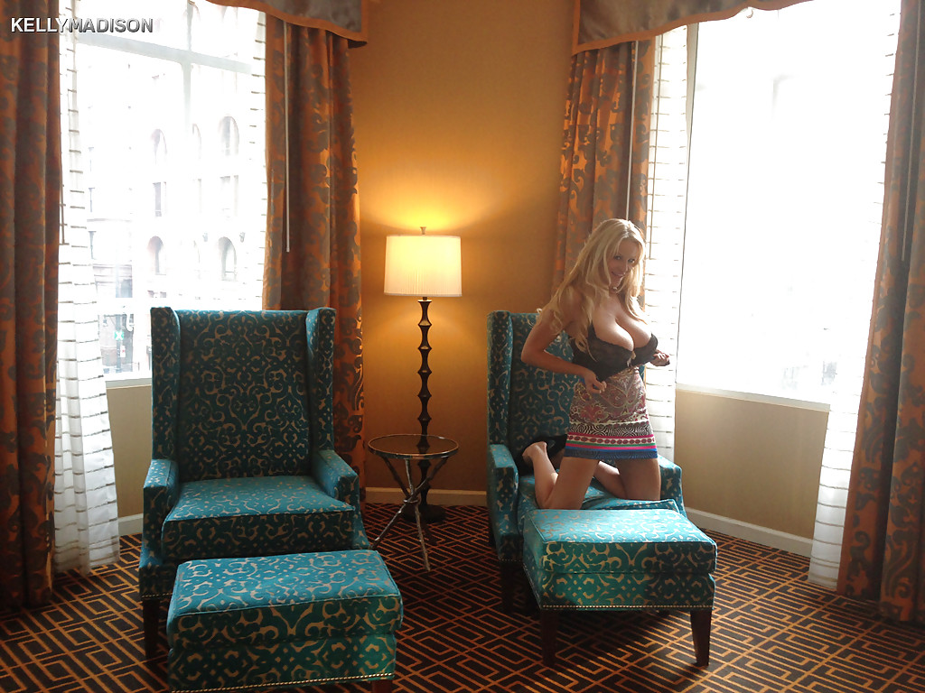 Грудастая блондинка раздевается в кресле гостиной - секс порно фото